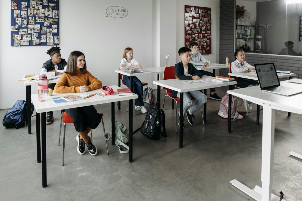 Diverse group of students learning attentively in a bright classroom setting.